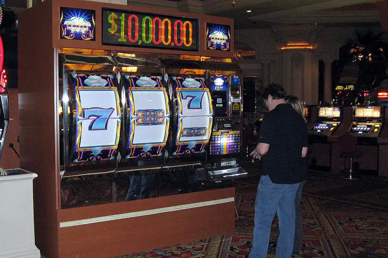 Man playing a giant slot machine on a casino floor